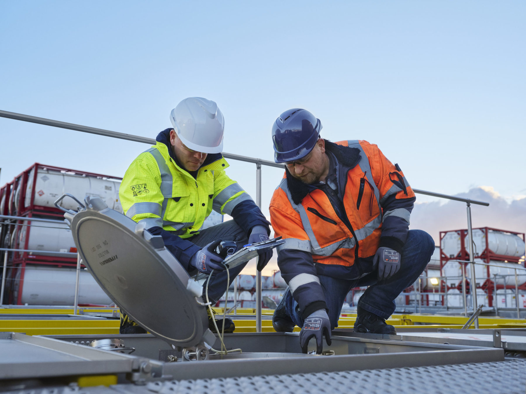Technicians taking measurements from the manhole of a liquid tank container - eurotainer
