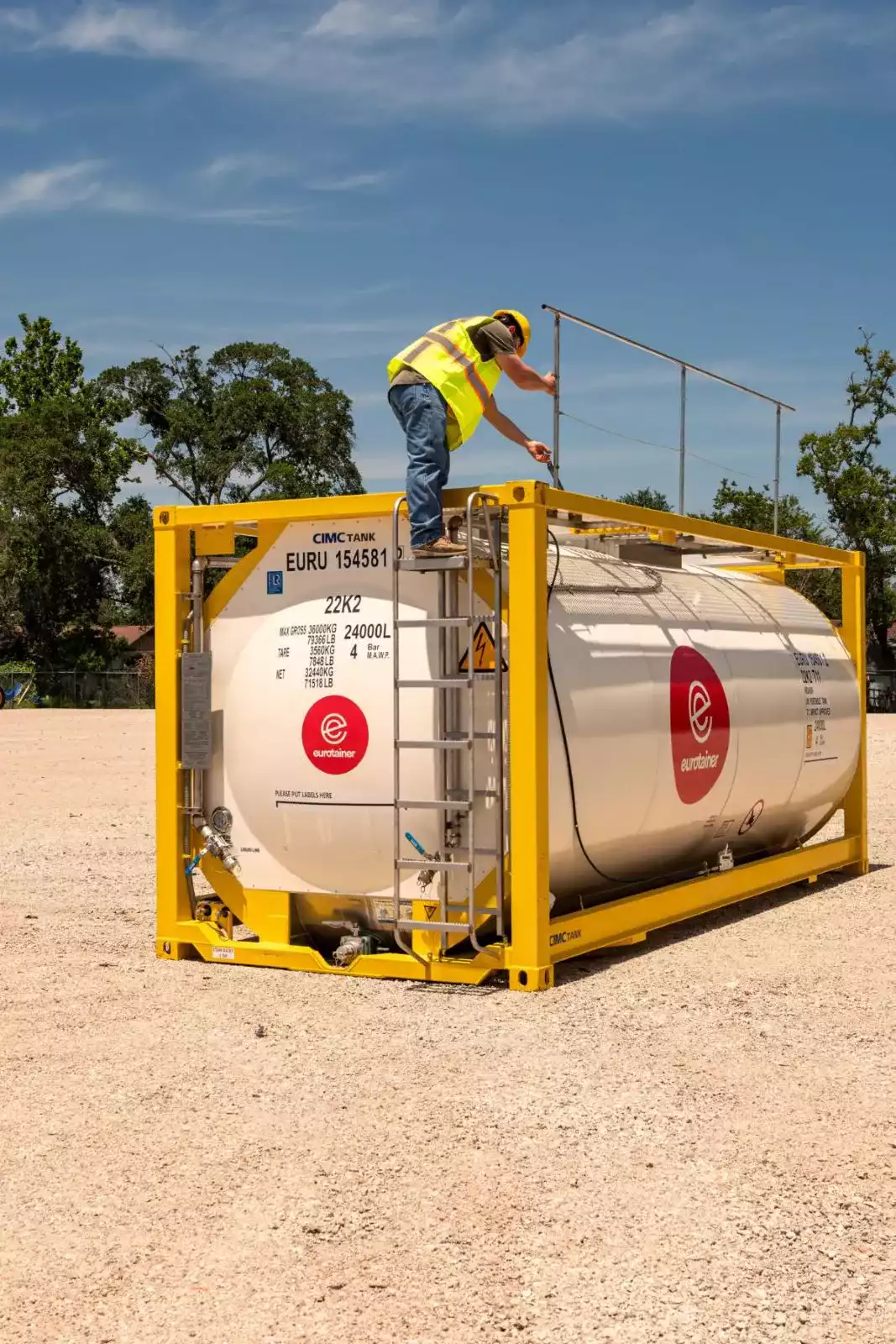Liquid tank container on depot with technician on walkways - eurotainer